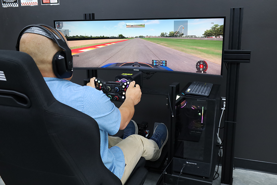 Man behind racing sim wheel.