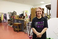 Woman stands in a room of props.