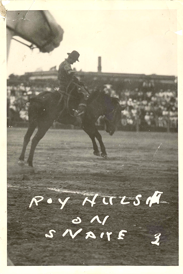 An old photo of a man on a horse.