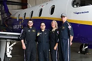 A group photo of people by a plane.