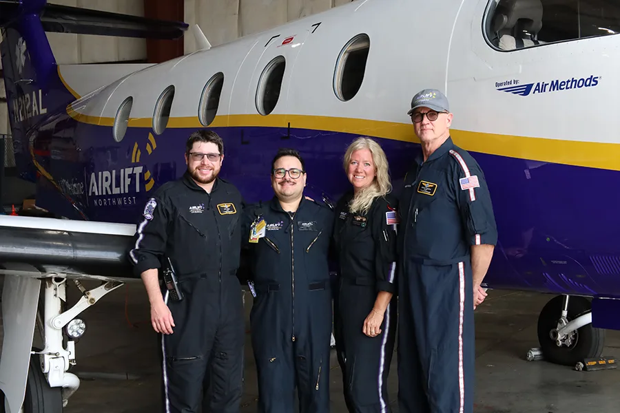 A group photo of people by a plane.