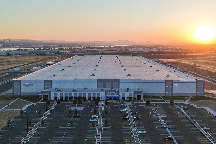 An aerial view of an Amazon facility at sunset.