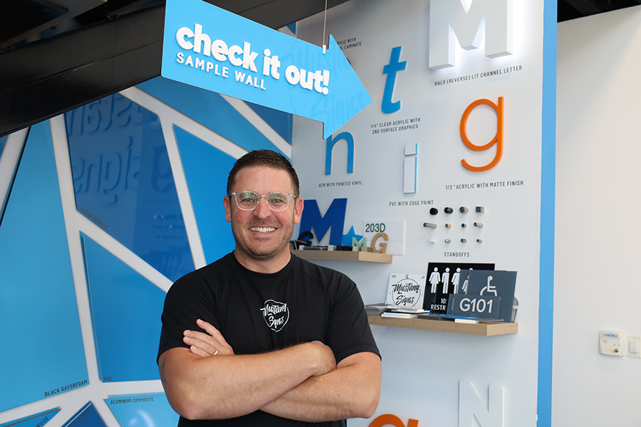 Man standing next to sign examples.