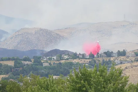 An airplane dropping fire retardant.