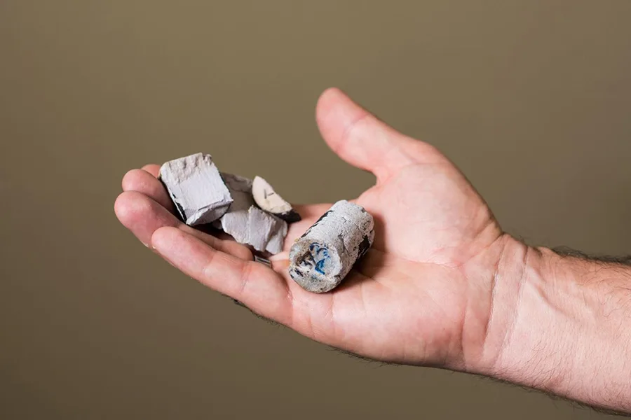 A hand holding a grey material.