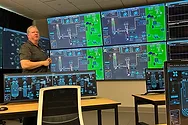 A man in a room with a lot of screens.