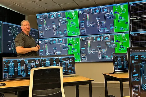 A man in a room with a lot of screens.