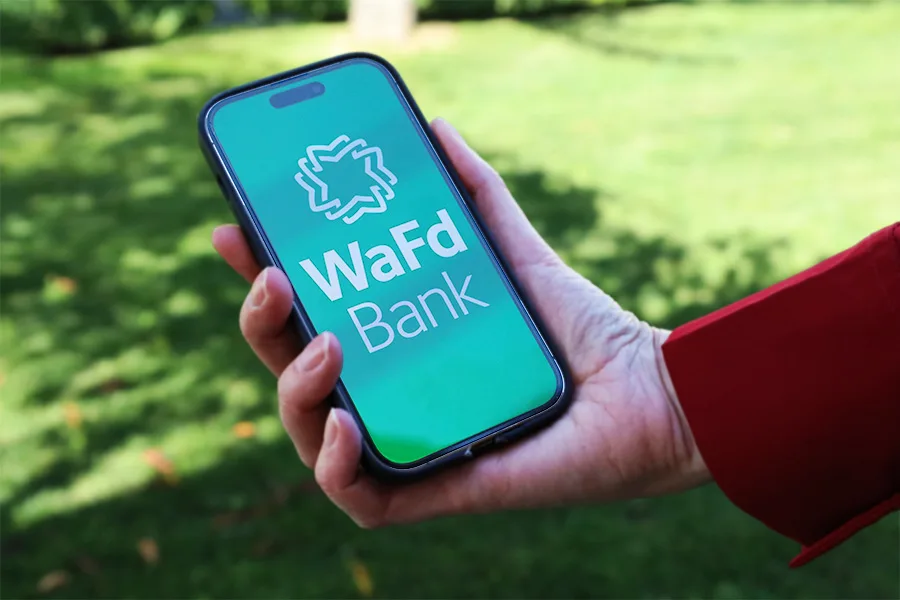 A person holding a phone with WaFd.