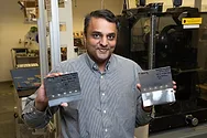 Man holds up metal plates.