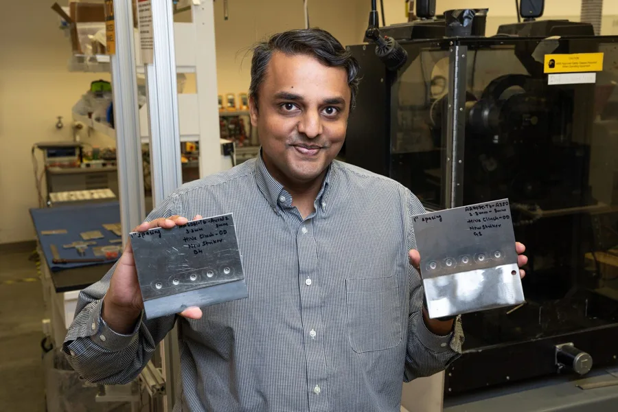 Man holds up metal plates.