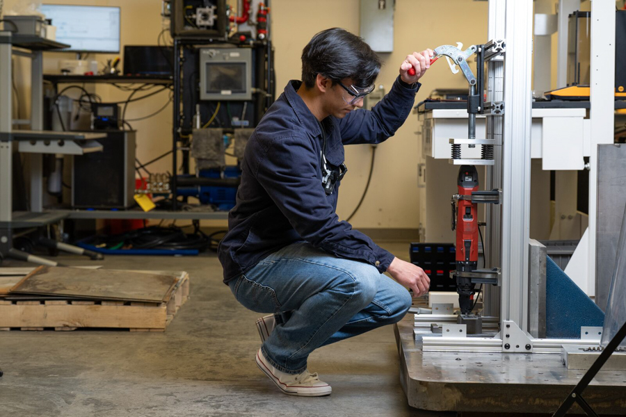 Man crouched using a machine.