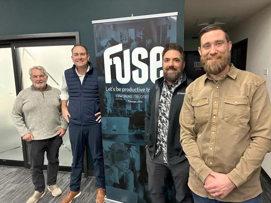 Four men standing near a sign that says, "Fuse".