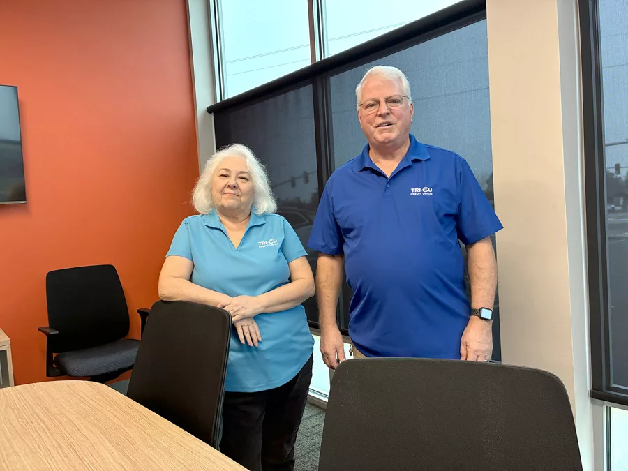 Two people standing by a desk.