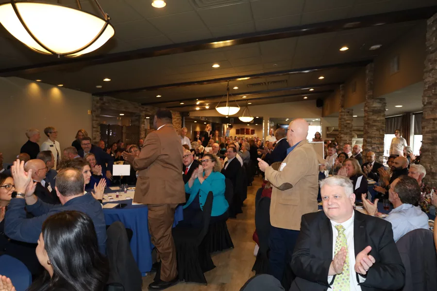 A room of people clapping.