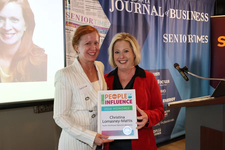 Two people on stage with an award.