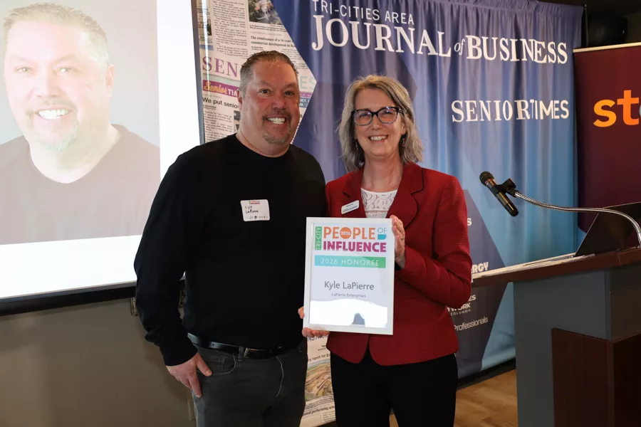Two people on stage with an award.