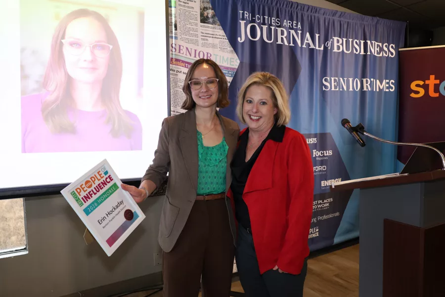 Two people on stage with an award.