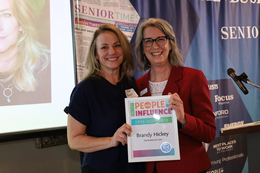Two people on stage with an award.
