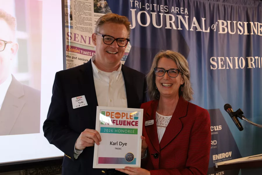 Two people on stage with an award.