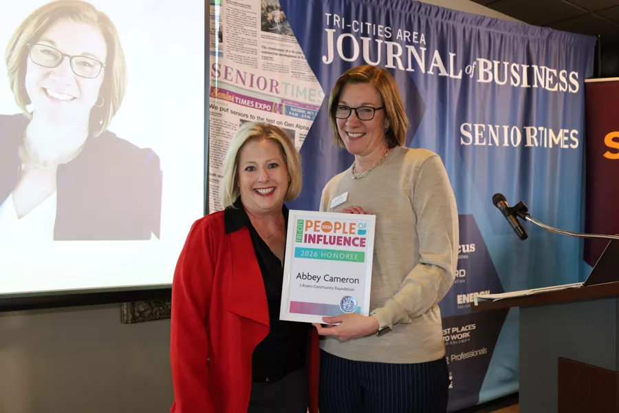 Two people on stage with an award.