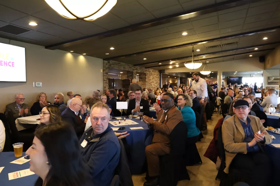 A crowd of people sitting at tables.