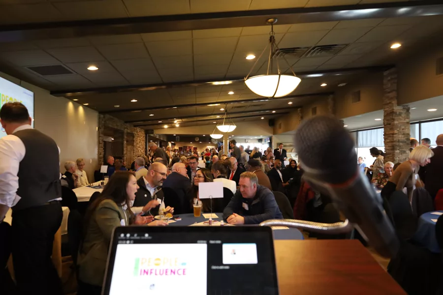 A crowd of people with a microphone in the foreground.