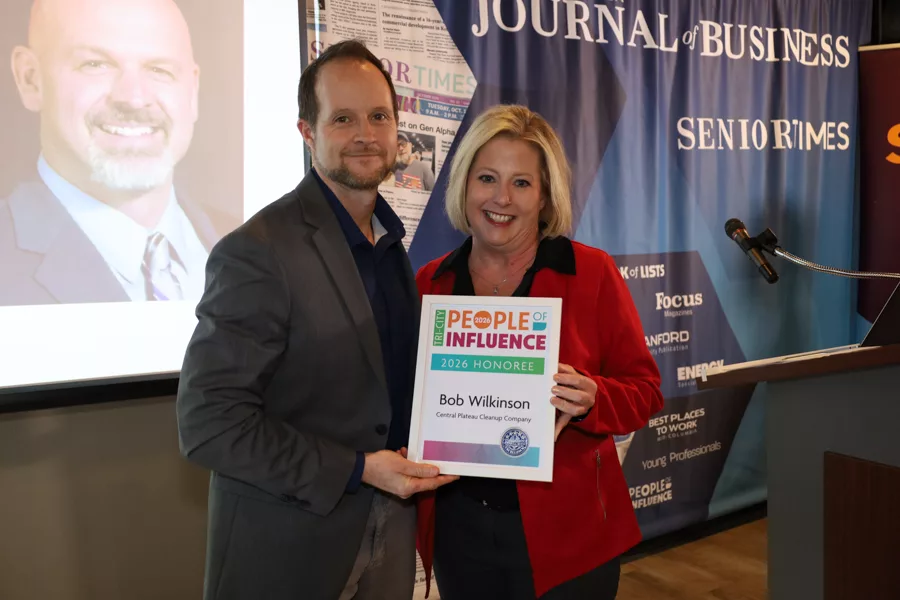 Two people on stage with an award.