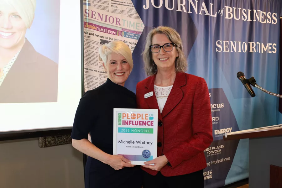 Two people on stage with an award.