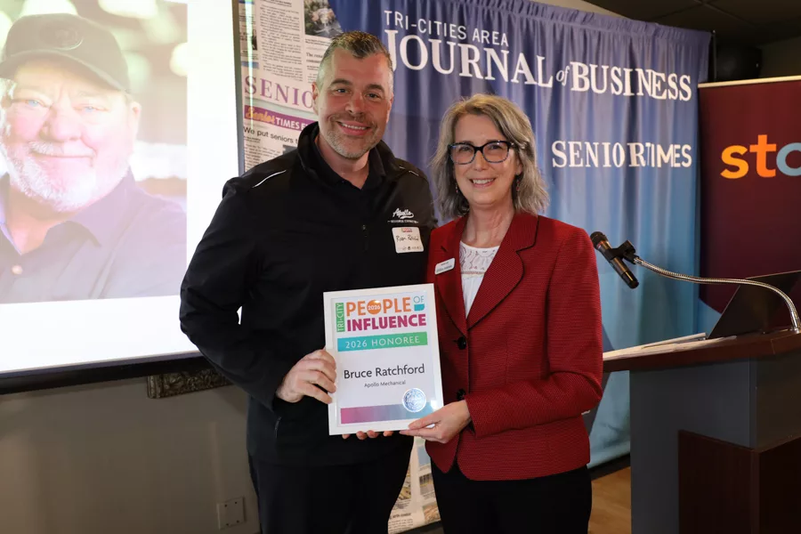 Two people on stage with an award.