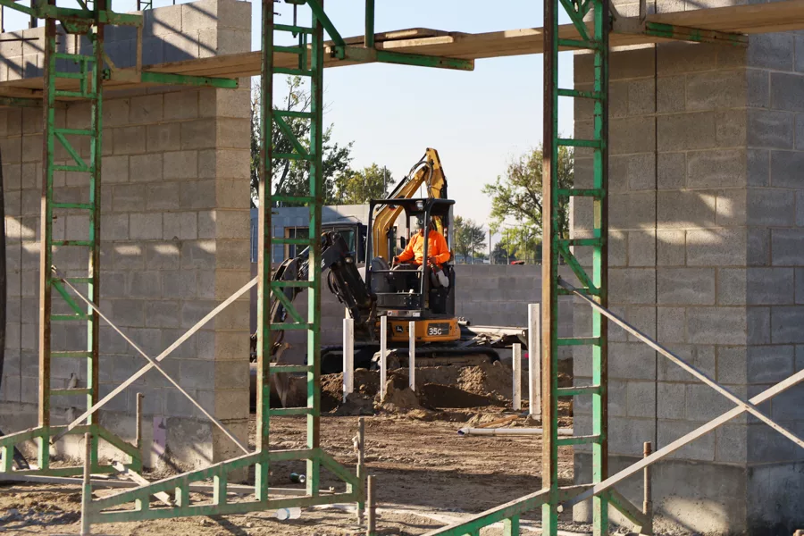 A man in an excavator on-site.