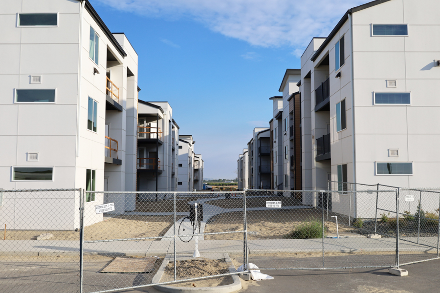 Apartments with a chain link fence in the foreground.