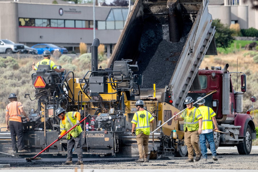 A crew laying asphalt.