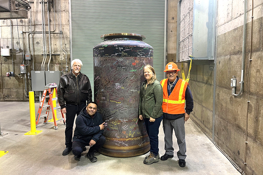 Ecology staff stand next to the first container of test glass at Hanford’s Waste Treatment and Immobilization Plant.