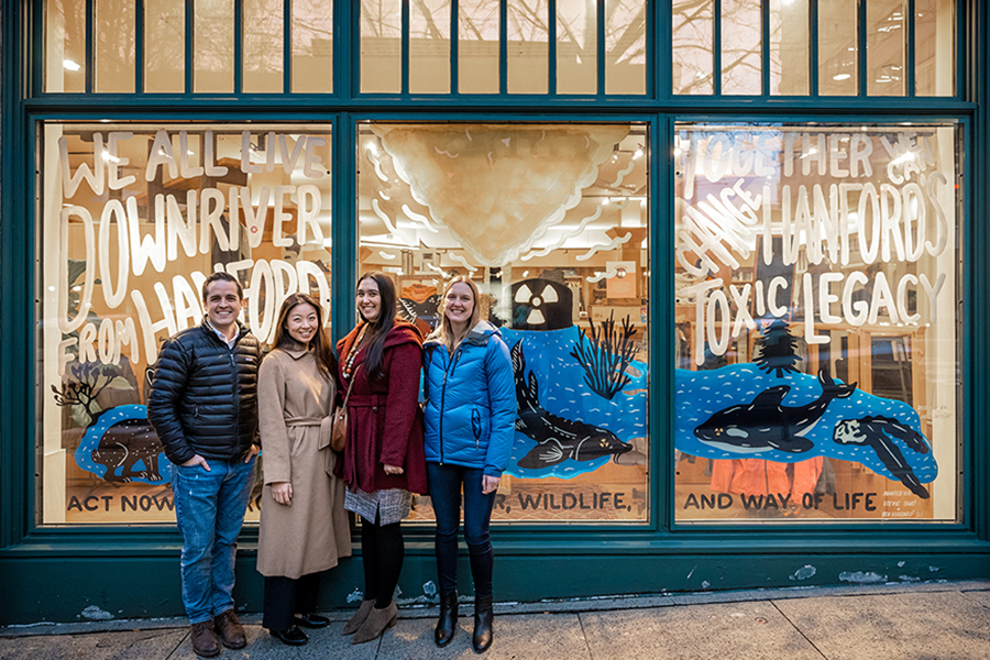 Hanford Challenge staff stand in front of the “We All Live Downriver” campaign mural on the windows of the Patagonia Seattle building.
