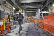 Worker walks through the Direct-Feed Low-Activity Waste (DFLAW) Facility with melter.
