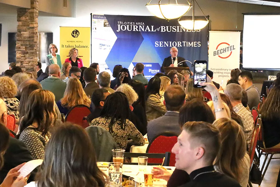 A crowd of people seated in a room. Paul Read is at a podium in front of the room.