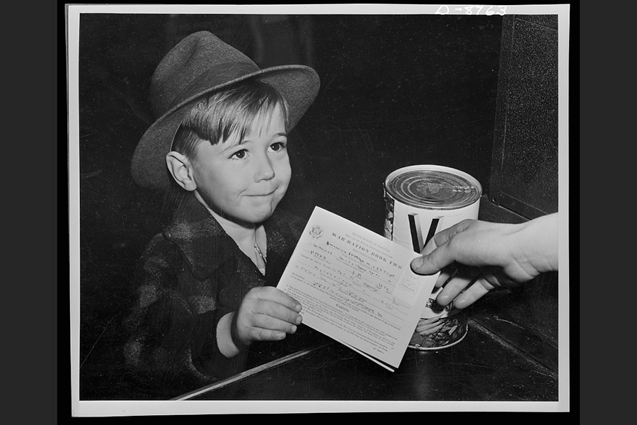 An old photo of a boy with a white booklet.