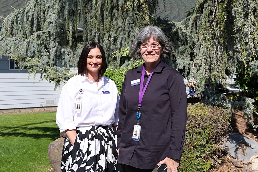 Two women standing in a courtyard.