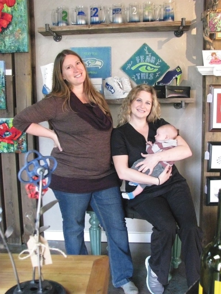Rachel Kronberg, left, and Jessica Hendrickson (holding baby Fischer Kronberg) own Locally Curated, a shop complete with spa, photography studio, and organic botanicals.