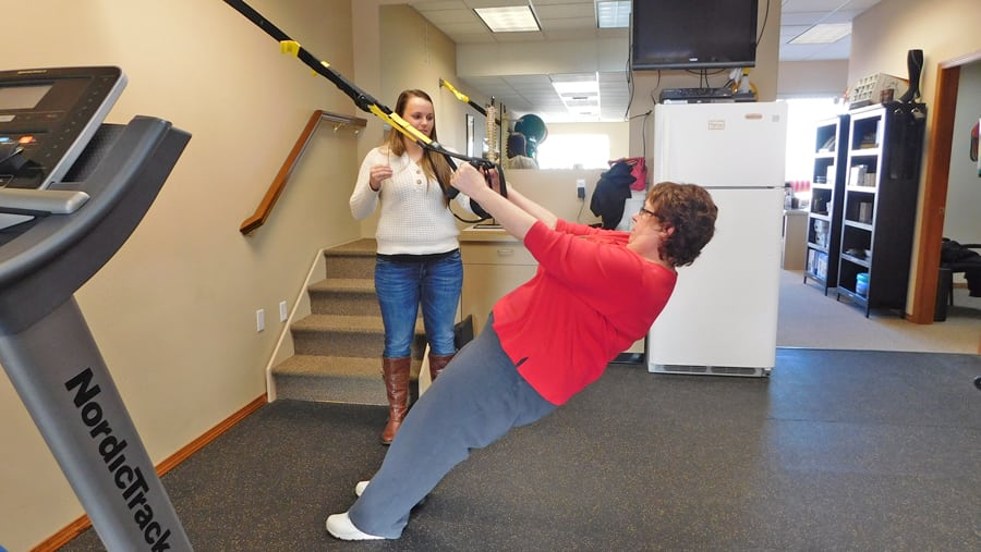 Glenda Higgins of Kennewick works out on a TRX machine, which uses a person’s body weight to build muscle strength.