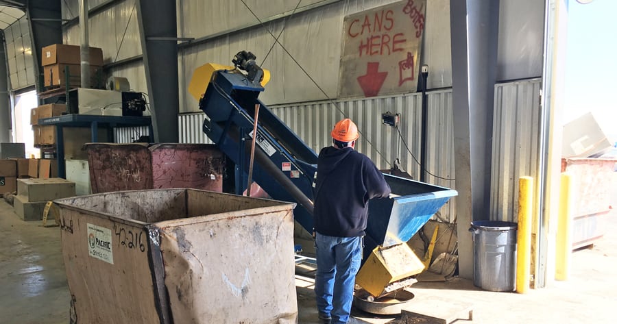 Pacific Steel & Recycling warehouse customer service specialist Shawn Jackson sends cans up the conveyor to be weighed. The company accepts an average of 400 to 500 pounds of cans per day.
