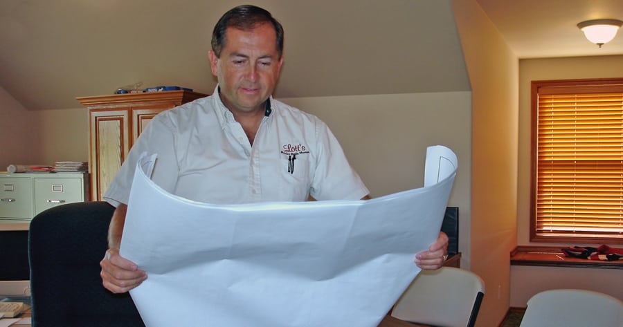 Brett Lott, co-owner of Brett Lott Homes, examines floor plans. As a certified aging-in-place specialist, he custom designs homes so clients can stay in them long term.