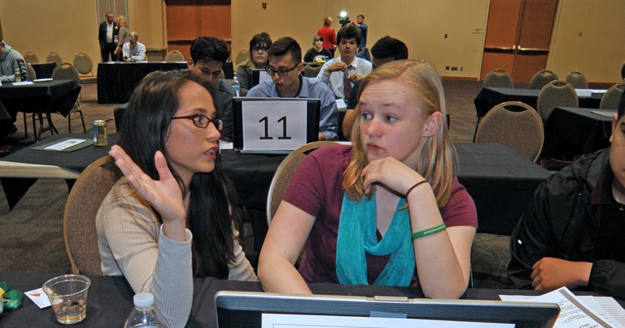 Bethany Cooper, left, and Alyssa Schultheiss of Kennewick High School confer during the Junior Achievement High-Tech Business Challenge, an online business simulation contest on April 25 at the Three Rivers Convention Center in Kennewick.