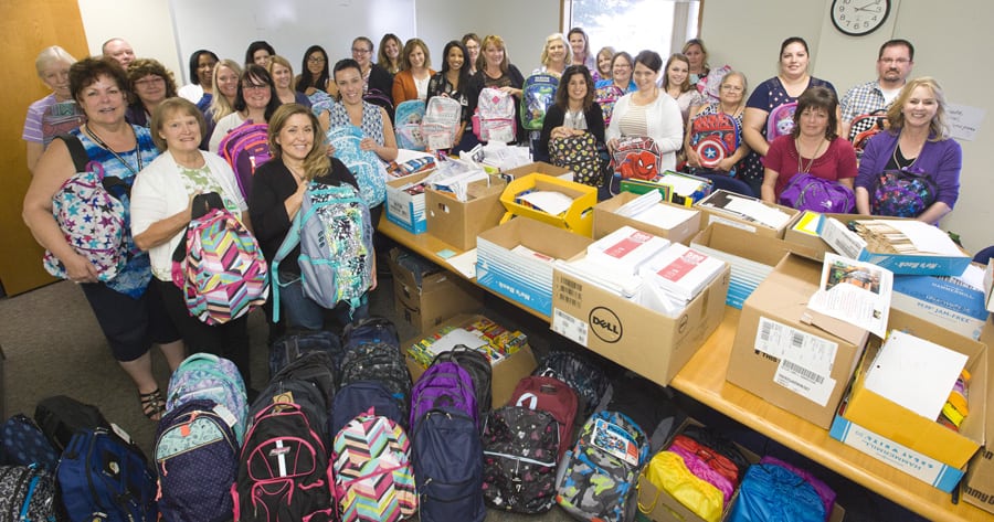 Members of Mission Support Alliance’s Synergy Network show off the backpacks they collected for Stack the Packs, a program that provides backpacks and school supplies to foster kids. The women’s group offers informal networking, formal panel discussions and community volunteer opportunities. (Courtesy MSA)