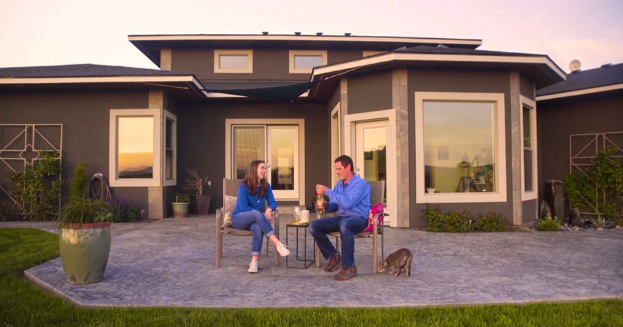 Actors Patrick Killoran and Amy-Lynne Darling share a bottle of wine on the deck of a home for sale in Kennewick. They appear in a video promoting the sale of a home listed with Tri-Cities Life Real Estate. Broker Steve Lambert said the video marketing tool is perfect for higher-end properties. (Courtesy Tri-Cities Life Real Estate)