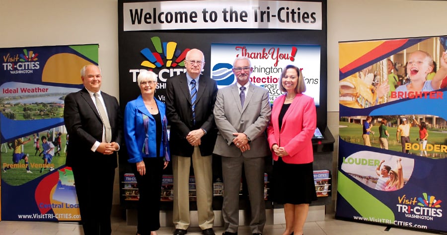 Ron Foraker, from left, former director of the Tri-Cities Airport; Port of Pasco Commissioner Jean Ryckman; Port of Pasco Commissioner Jim Klindworth; Mark Lindholm of Washington River Protection Solutions; and Kris Watkins, president and CEO Visit Tri-Cities, attend a June event to dedicate an interactive information kiosk at the Tri-Cities Airport. A nationwide search for a new CEO for Visit Tri-Cities kicks off this month to replace Watkins, the longtime leader of the tourism agency. (Courtesy Visit Tri-Cities)