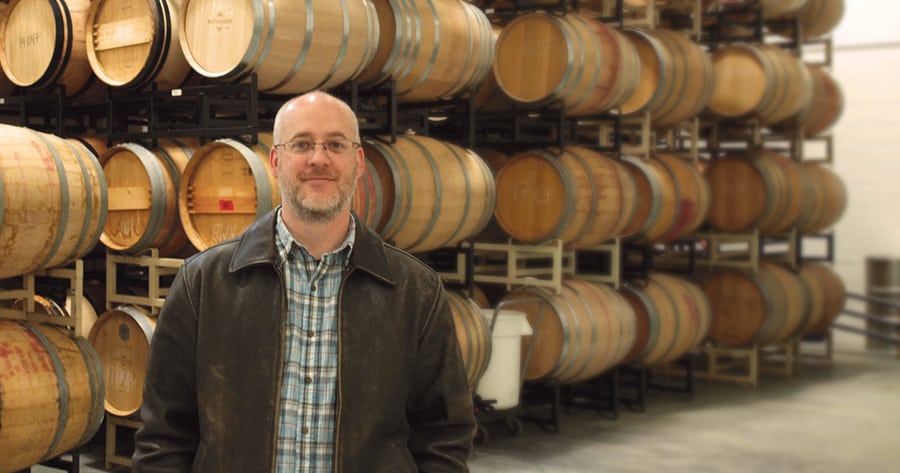 Bart Fawbush stands in his production room at Columbia Gardens Wine and Artisan Village on Columbia Drive. The barrels of aging wine behind him will be bottled into about 1,100 cases within a single day next summer. Fawbush plans to open his doors before Christmas.