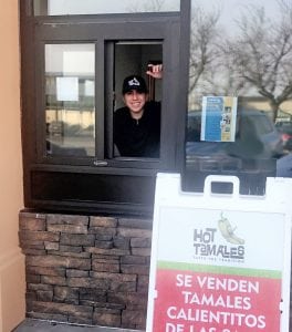 Hot Tamales Fabian Perez, the nephew of co-owner Paulina Perez, smiles through the new walk-up window where customers can buy or pick-up pre-ordered tamales at 110 S. Fourth Ave. in downtown Pasco. (Courtesy Hot Tamales)