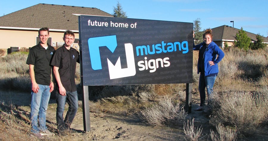 The Mustang Sign Group’s owners have bought land at 10379 W. Clearwater Ave. in Kennewick and expect to break ground on a 12,000-square-foot building within the next 60 days. From left are Production Manager Devin Nielsen, Sign Ninja Amos Williams and co-owner Lauren Wang.