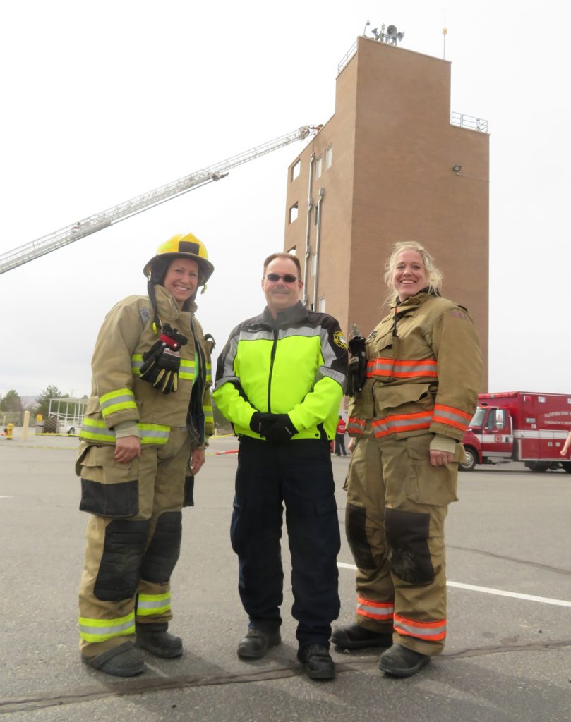 Melanie Hair, from left, general manager and founder of the Tri-Cities Area Journal of Business, Benton Fire District 4 Chief Bill Whealan and Capt. Bonnie Benitz stand in front of the seven-story building participants in Fire Ops 101 had to climb on March 23 as part of a multi-agency training event.